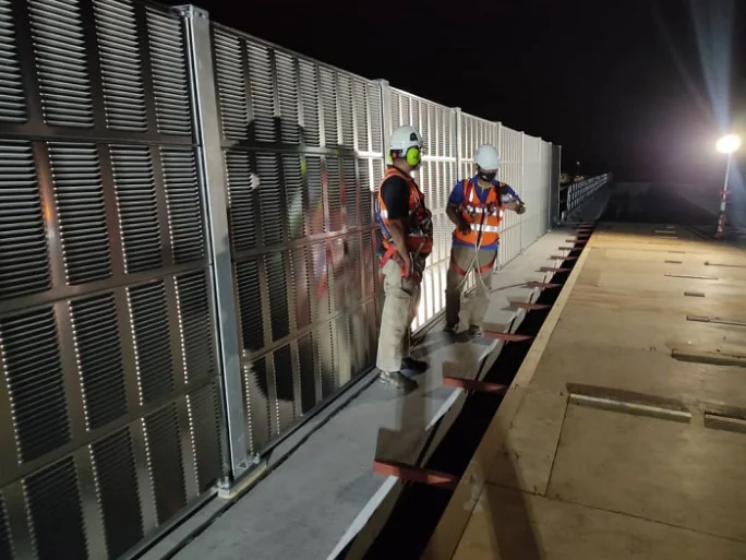 Engineers conducting acoustic testing beside LRT3 noise barriers